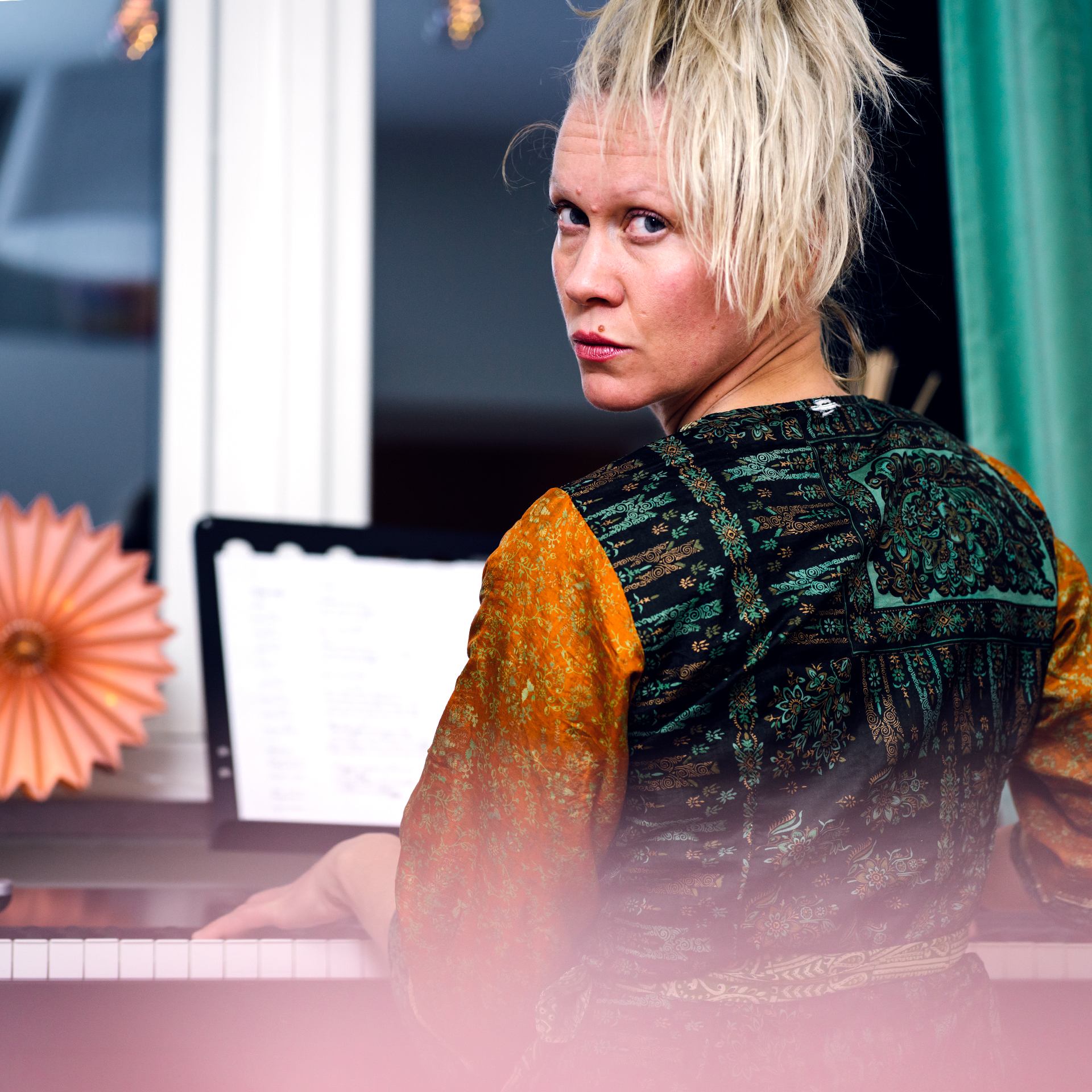 Anna Sköld playing the piano, looking over her shoulder